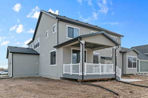 Back of house featuring a wooden deck and stucco siding
