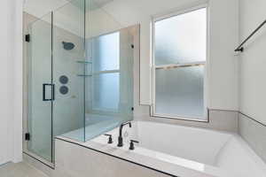 Full bath featuring a stall shower and a bath