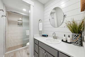 Full bathroom featuring vanity, a stall shower, and recessed lighting