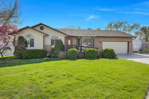 Ranch-style house featuring brick siding, concrete driveway, an attached garage, and a front lawn