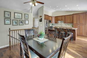 Dining area featuring light wood-style flooring, vaulted ceiling, ceiling fan, and recessed lighting