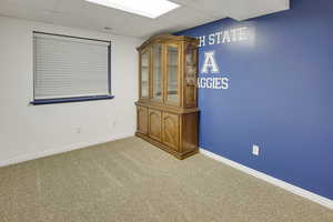 Unfurnished room featuring carpet flooring and a paneled ceiling