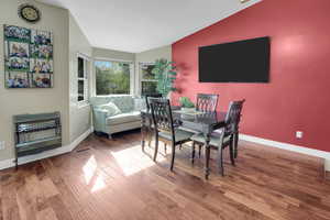 Dining space featuring heating unit, wood finished floors, and lofted ceiling