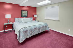 Bedroom with a paneled ceiling and carpet