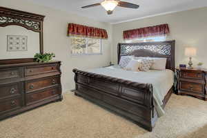 Bedroom with light colored carpet and a ceiling fan