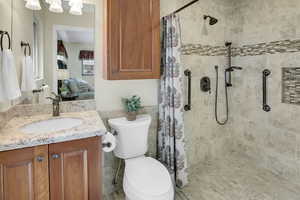 Bathroom featuring ensuite bath, vanity, and a shower stall