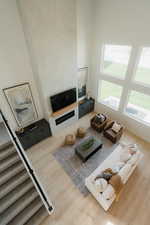 Living room featuring a high ceiling and light wood-type flooring