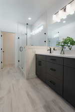 Full bathroom with double vanity and a shower stall