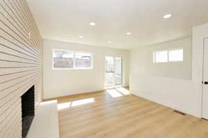 Unfurnished living room featuring light wood-style floors, a fireplace, and recessed lighting