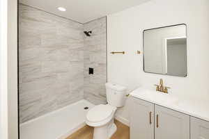 Bathroom with vanity, a shower stall, and light wood-type flooring