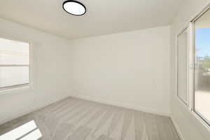 Empty room with healthy amount of natural light and light colored carpet