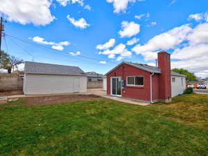 Back of property with an outbuilding, brick siding, and a chimney