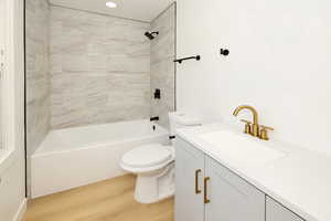 Bathroom featuring vanity, light wood-type flooring, and washtub / shower combination