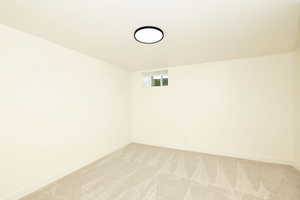 Spare room featuring light carpet and baseboards