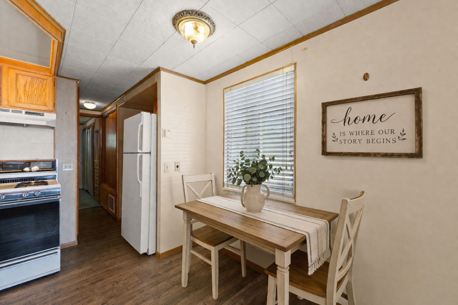 Dining space with crown molding and dark wood-style floors