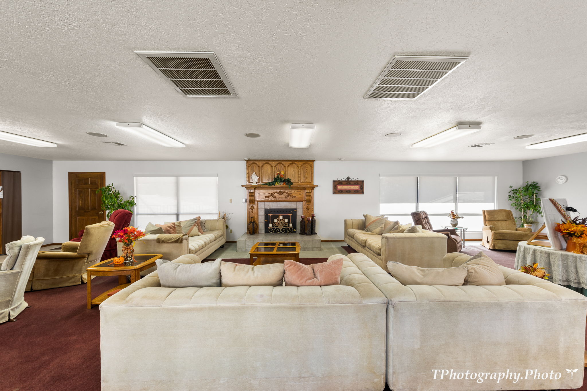 Living room featuring a textured ceiling, a tile fireplace, and carpet flooring
