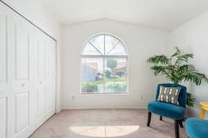 Living area featuring light colored carpet and lofted ceiling