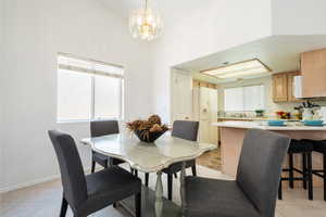 Dining area with suspended lighting and light tile patterned floors
