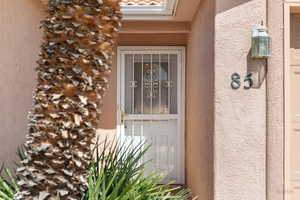 Doorway to property featuring stucco siding