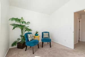 Sitting room featuring vaulted ceiling and light colored carpet
