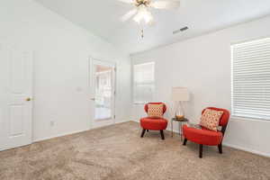 Living area with ceiling fan, lofted ceiling, and carpet floors