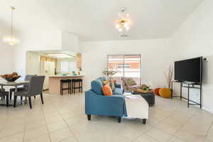 Living room with light tile patterned flooring, plenty of natural light, and suspended lighting