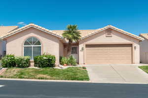 View of front of home featuring stucco siding, a garage, driveway, and a tile roof
