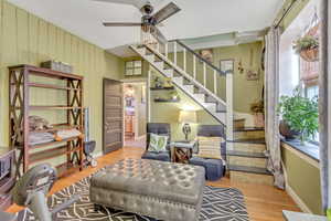 Sitting room with light wood-style floors and a ceiling fan