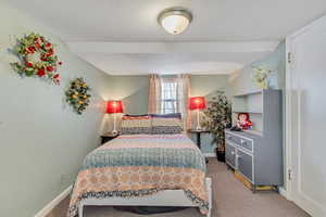 Bedroom featuring light carpet and baseboards