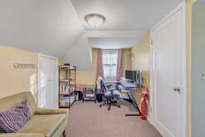 Office space featuring light carpet and lofted ceiling