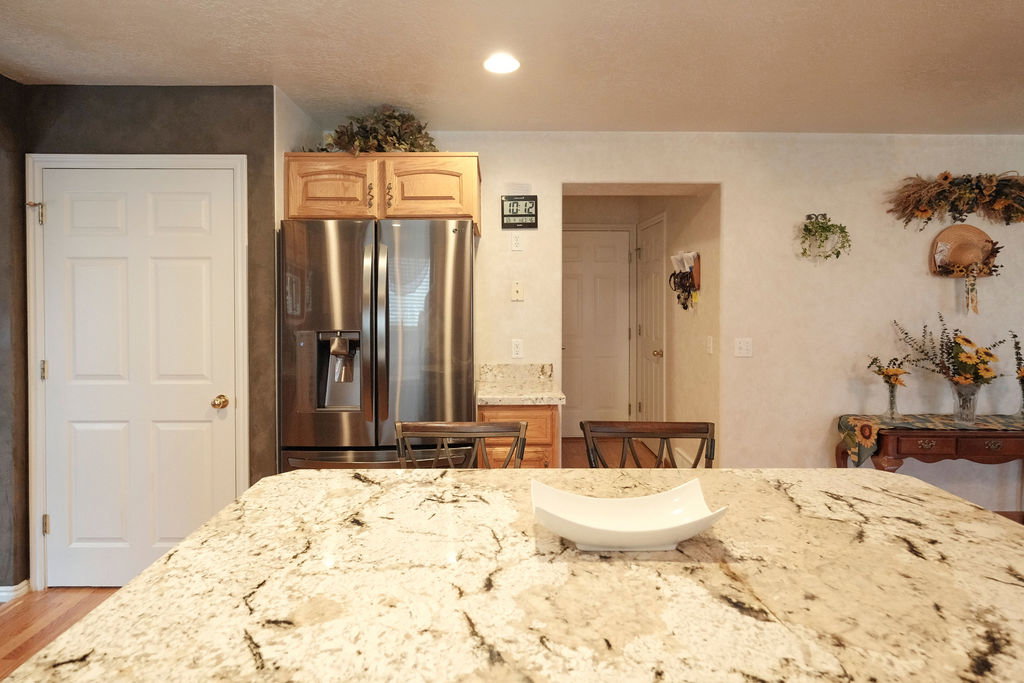 Spacious kitchen island featuring a light-toned granite countertop with natural veining