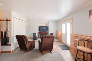 Recreation room featuring carpet flooring, natural wood wainscoting, French doors, a built-in media console, and recessed lighting