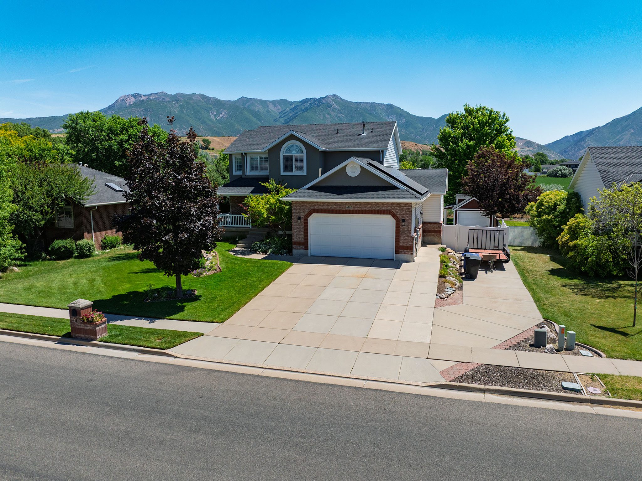 Suburban residence featuring a two-story design, a two-car garage, and a brick façade