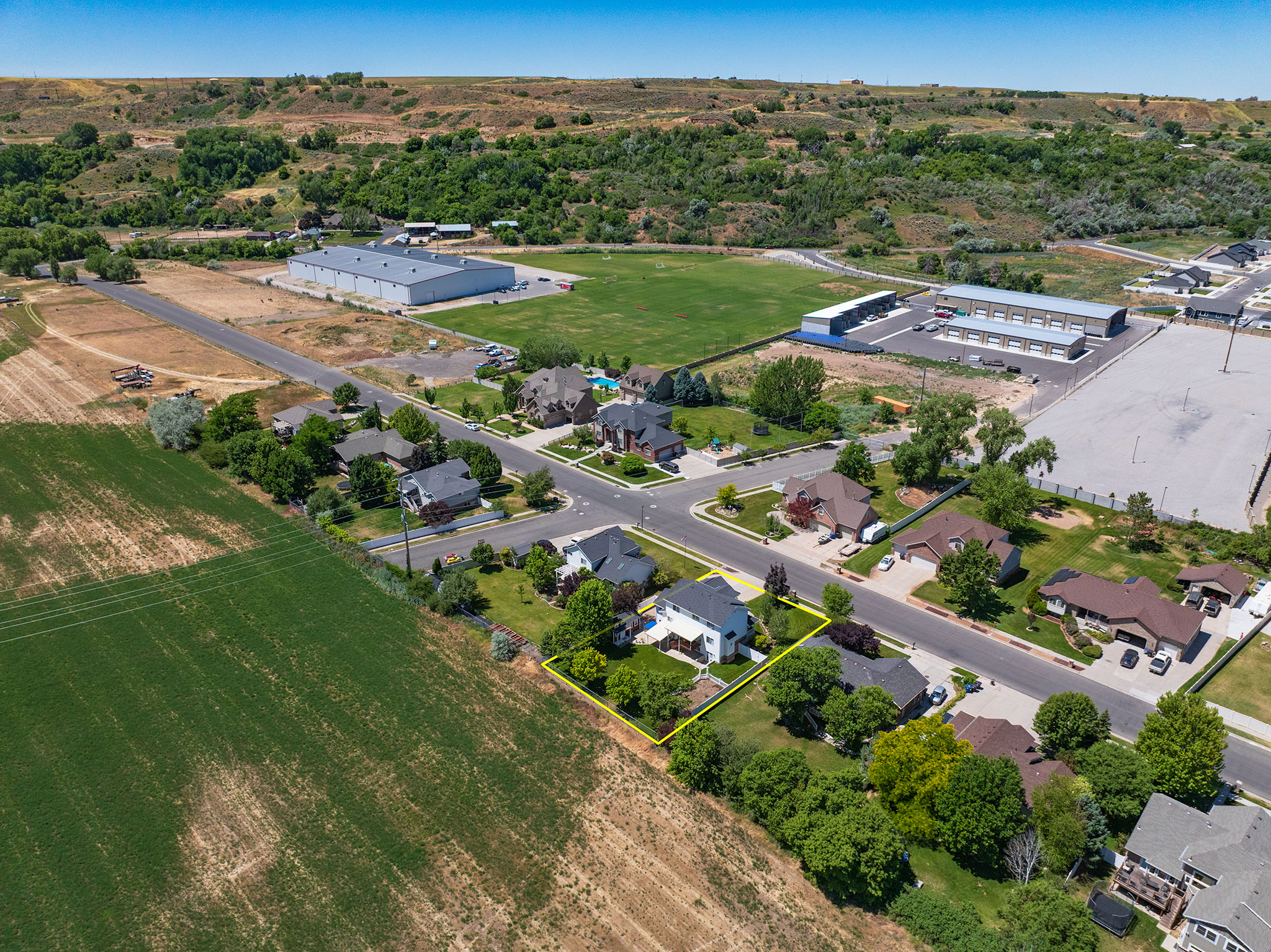 Aerial perspective showcasing the property's expansive lot with mature trees and a manicured lawn
