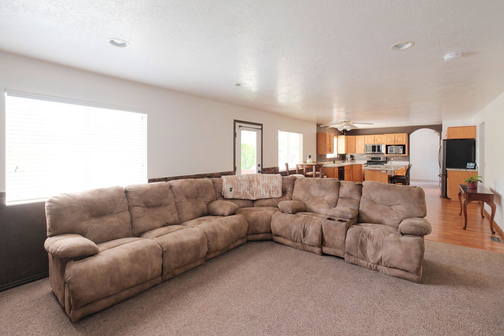 Spacious living area with carpet flooring and ample natural light from a large window