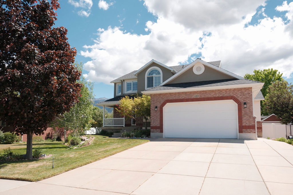 Two-story residence featuring a brick and siding exterior with an attached two-car garage