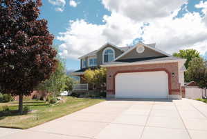 Two-story residence featuring a brick and siding exterior with an attached two-car garage