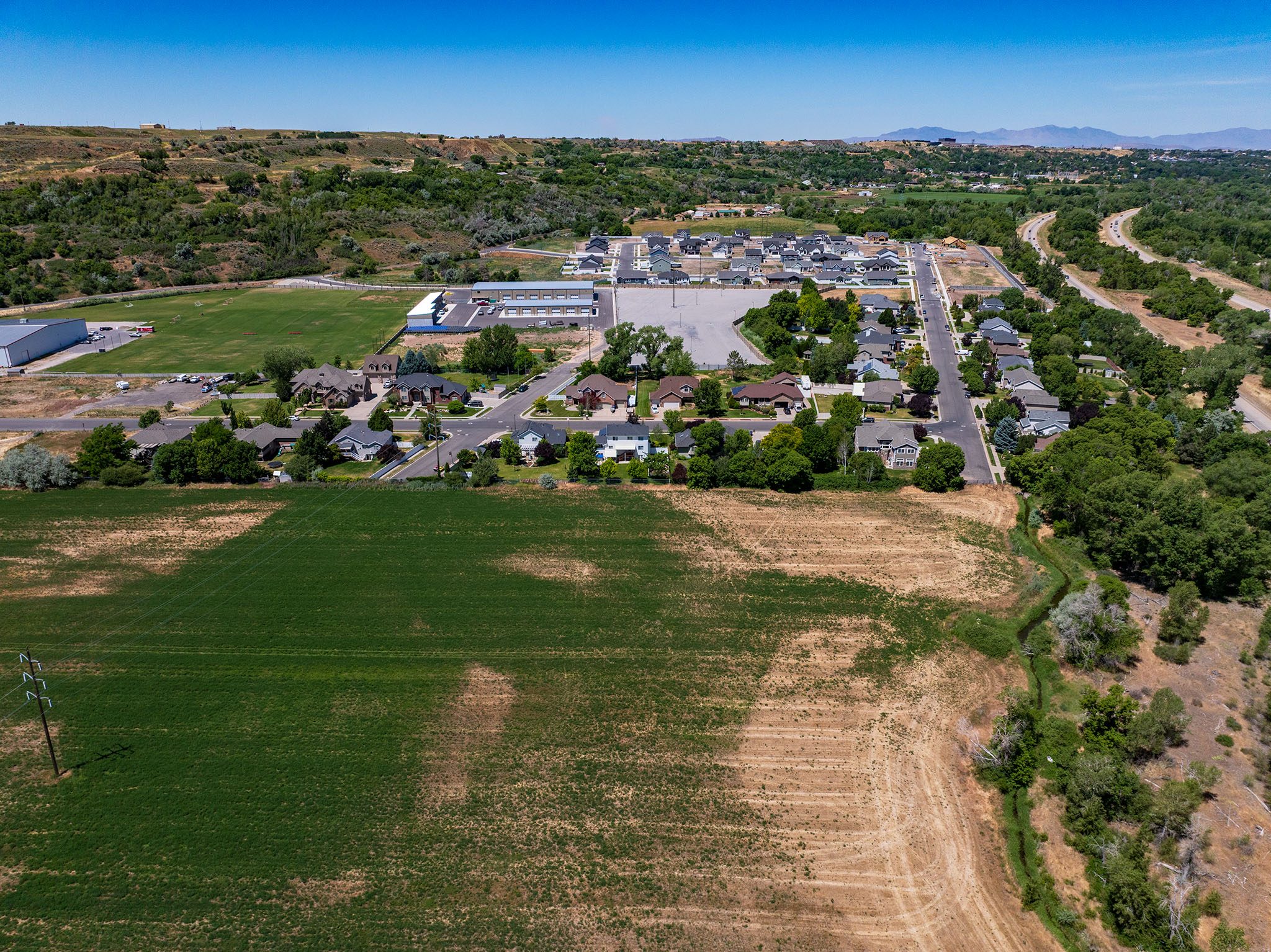Expansive land parcel featuring open fields, mature trees, and natural vegetation