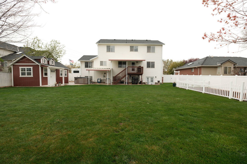 Expansive green lawn with a white vinyl picket fence
