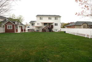 Expansive green lawn with a white vinyl picket fence