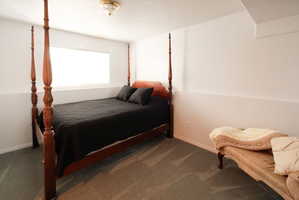 Recessed window with natural light, neutral wall colors, textured carpet flooring, and a flush mount ceiling light fixture