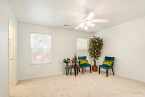 Sitting room with ceiling fan and light colored carpet
