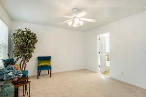 Sitting room featuring light carpet and ceiling fan