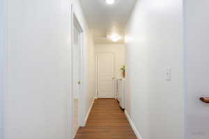 Corridor featuring dark wood-type flooring and washing machine and clothes dryer