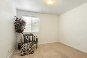 Living area with light colored carpet and a textured ceiling