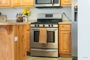 Kitchen featuring stainless steel appliances, light countertops, and light wood finish cabinetry