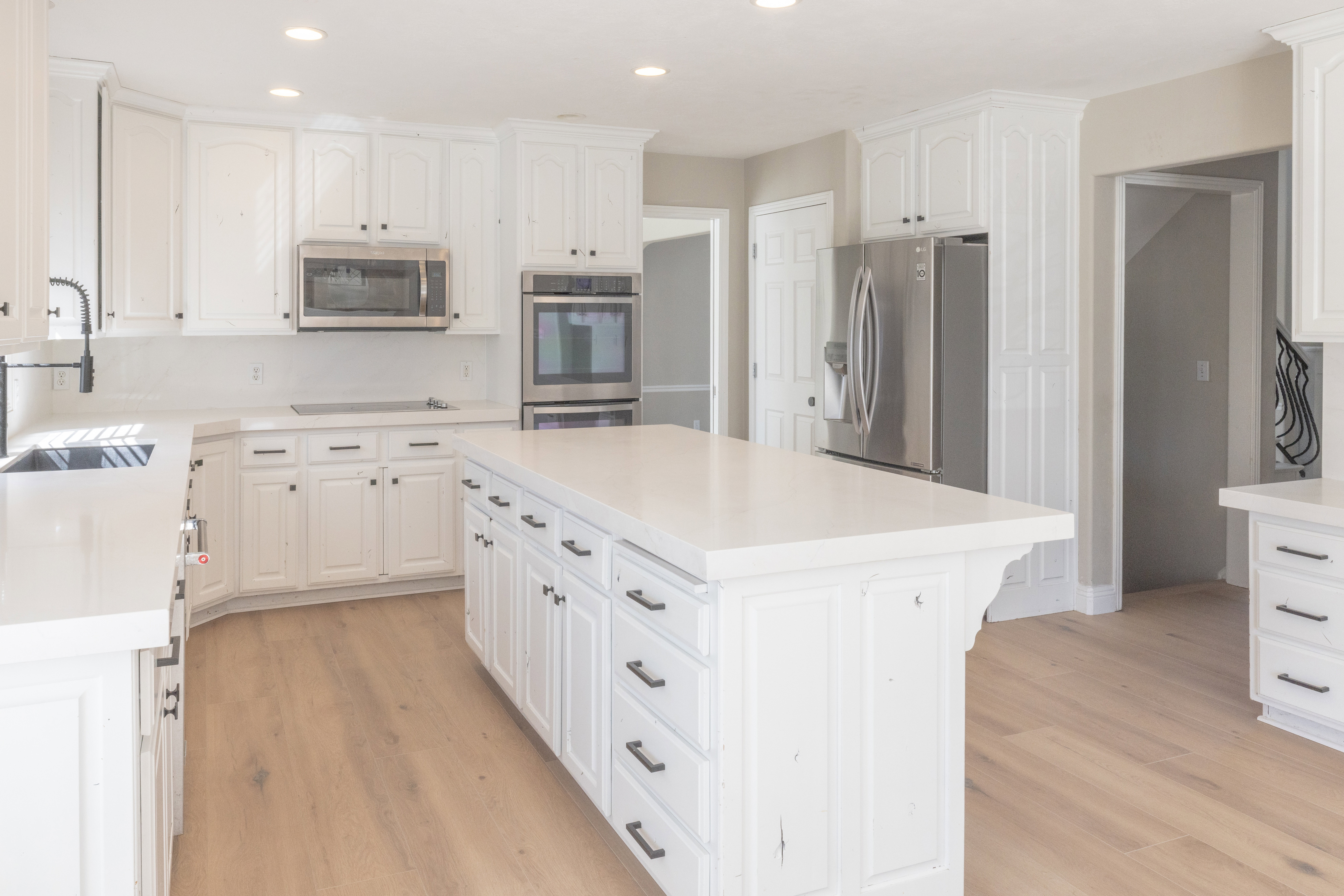 Kitchen with white cabinetry, stainless steel appliances, recessed lighting, and a center island