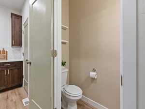 Bathroom with light wood-style floors, decorative backsplash, and vanity