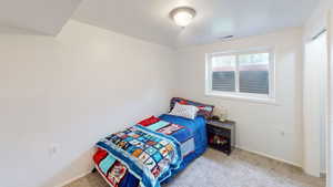 Bedroom featuring light carpet and baseboards