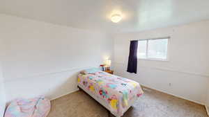 Bedroom featuring light carpet and baseboards